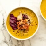 two bowls of soup on a marble table